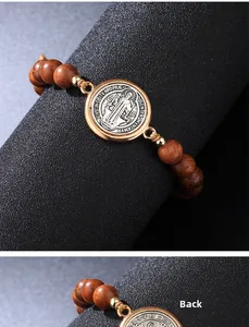 Detailansicht des St. Benedikt Holzperlenarmbands mit gravierter Metallmedaille auf Sockel