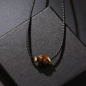 Collier minimaliste en œil de tigre avec perles dorées sur cordon noir, style élégant