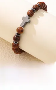 Détail d'un bracelet en perles de bois avec pendentif croix sur support d'exposition