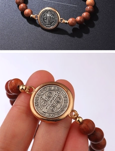 Makrodetail der Benediktus-Medaille mit rotbraunen Holzperlen und verstellbarer Schnur