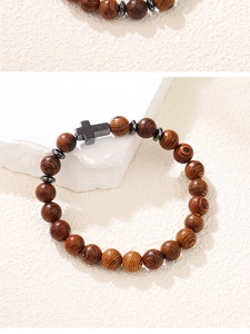 Détail d'un bracelet en perles de bois brun foncé avec un pendentif en croix noire