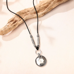 Collier bohème avec pendentif disque argenté martelé et perles sur cordon noir