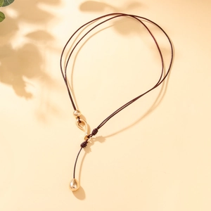 Bohemian style dark brown leather cord necklace with gold bead accents and teardrop pendant