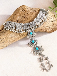 Antique silver boho necklace with turquoise stones and metal fringe on wood block