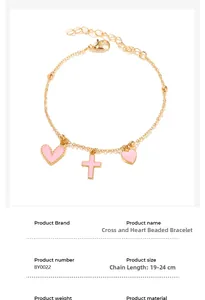 Détail du bracelet chaîne dorée avec breloques cœur et croix en émail rose et fermoir mousqueton
