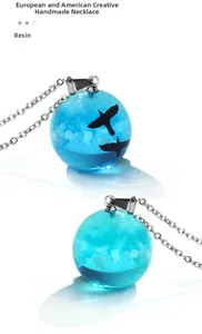 Detailed macro view of the 2cm resin sphere pendant with blue sky and bird motifs