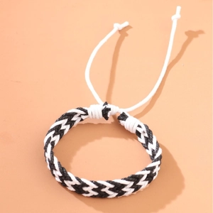 Handmade woven cord bracelet in black and white with an adjustable pull string design