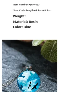 Close-up of sky blue resin pendant necklace with clouds and bird silhouette on a dark stone