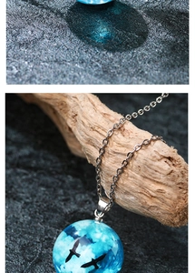 Detailed macro view of the blue sky white clouds resin ball pendant with birds