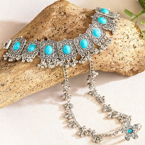 Ethnic bohemian silver alloy bracelet with turquoise stone on natural wood background