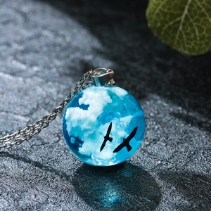 Creative resin glass ball necklace featuring blue sky, white clouds, and flying birds