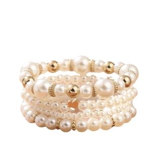 Four-piece layered faux pearl bracelet set with golden beads and a heart charm