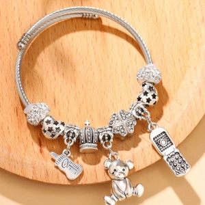 Silver beaded charm bracelet with bear and clover pendants on a rope chain texture