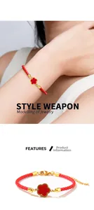 Detail of red braided string bracelet with a golden four-leaf clover pendant and adjustable clasp