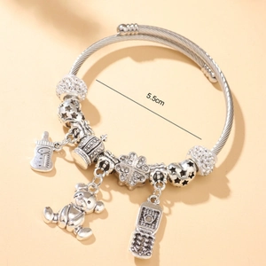 Silver charm bracelet with teddy bear and crown pendants on twisted wire cable band