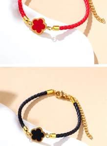 Detailed close-up of woven red and black rope bracelets with gold clover charms