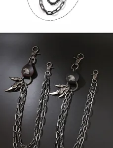 Detail of punk metal waist chain featuring eagle head emblem and vintage claw pendants