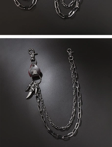 Detail of double-layer punk pants chain with eagle leather patch and claw charms