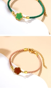Detailed macro view of woven red and green bracelets with clover pendants and gold clasps
