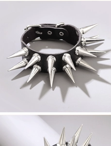 Dettaglio di bracciale punk in pelle nera con punte in metallo argento e fibbia regolabile