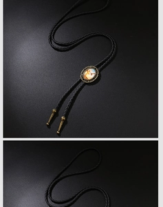 Dettaglio di un bolo tie vintage con ciondolo a croce dorata su cuoio intrecciato nero