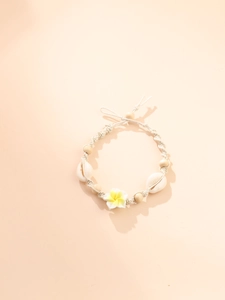 Detail of bohemian shell anklet with frangipani flower and white cotton braided cord