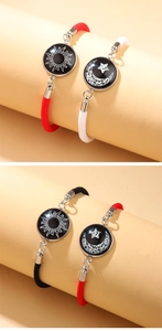 Detail view of woven couple bracelets with sun and moon luminous glass cabochon charms