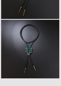 Detail of vintage guitar head bolo tie with green inlay and gold treble clef symbol