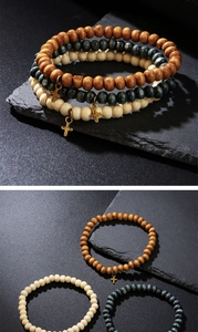 Three-piece wooden bead bracelet set with bronze cross charms and natural textures
