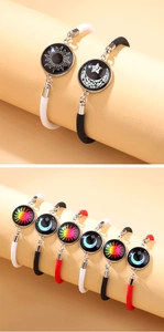 Detail of sun and moon couple bracelets with glowing glass pendants on woven cords