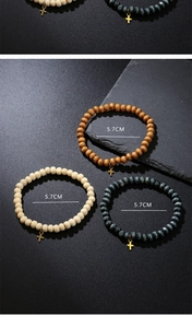 Three-piece stretch bead bracelets featuring small gold cross charms on a textured background