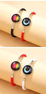 Detailed view of sun and moon couple bracelets with glowing glass pendants on woven cords