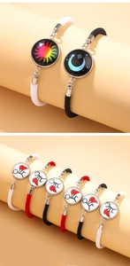 Detailed close-up of sun and moon woven couple bracelets with luminous glass charms