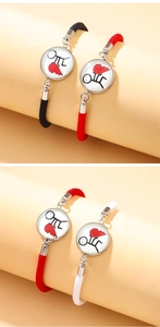 Close-up of matching woven couple bracelets with creative sun and moon heart pendants