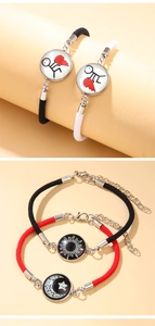 Close-up of woven couple bracelets with sun moon charms and heart pendants