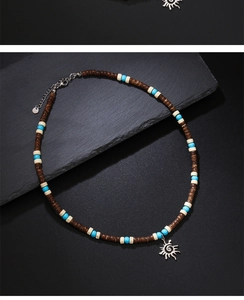 Macro shot of bohemian wooden bead necklace featuring a silver sun pendant on rock