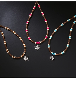 Macro view of Bohemian wooden bead necklaces featuring silver sun pendants on black background