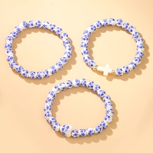 Three-piece set of blue and white ceramic beaded bracelets with cross and heart charms