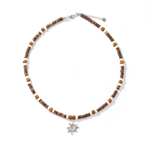Bohemian beaded necklace with wood beads and silver sun pendant on white background