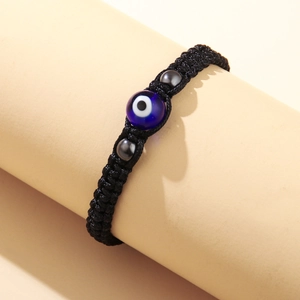 Bracciale in corda nera intrecciata a mano con perla malocchio blu e accenti simmetrici