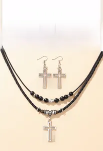 Dettaglio della collana di perline con croce d'argento e orecchini pendenti coordinati