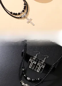 Dettaglio del set collana con pendente a croce e orecchini abbinati con cordino nero