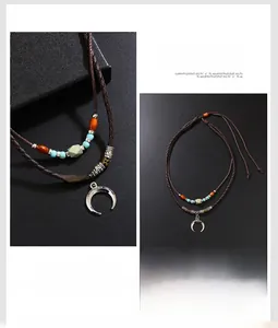 Detail of silver crescent moon pendant with turquoise beads on woven leather cord