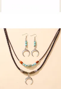 Detail of bohemian set with crescent moon pendants and turquoise beads on woven cord
