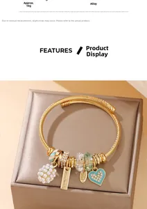 Detail of gold handmade bracelet featuring pearl cluster and blue enamel heart charm