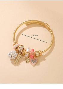 Detail of handmade gold wire-wrapped bracelet with 5.5cm diameter and pearl heart charms