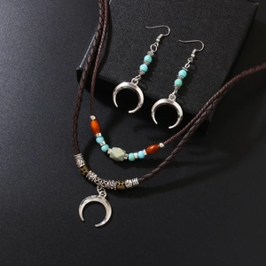 Retro bohemian moon necklace and earrings set with turquoise beads on black background