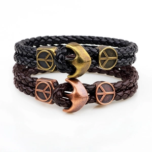 Detail of retro braided leather bracelets with anchor clasp and metal peace symbols