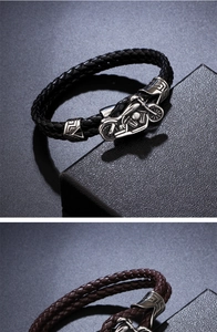 Close-up of black and brown braided leather bracelets with detailed motorcycle buckles