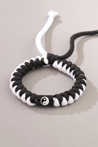 Detailed view of handmade woven rope bracelet featuring Yin Yang symbol on central bead
